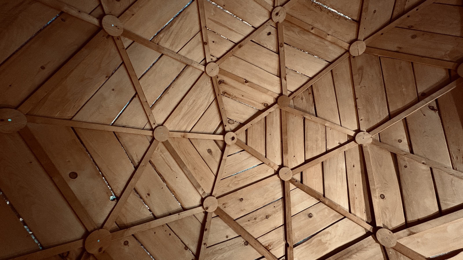 Geometric cedar ceiling of the geodesic dome, seen from the bench